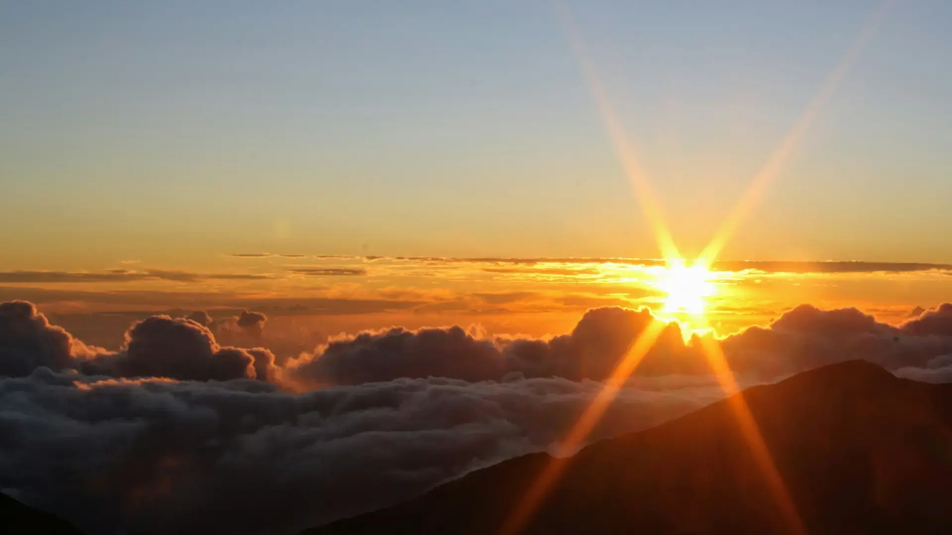 Sun setting over clouds