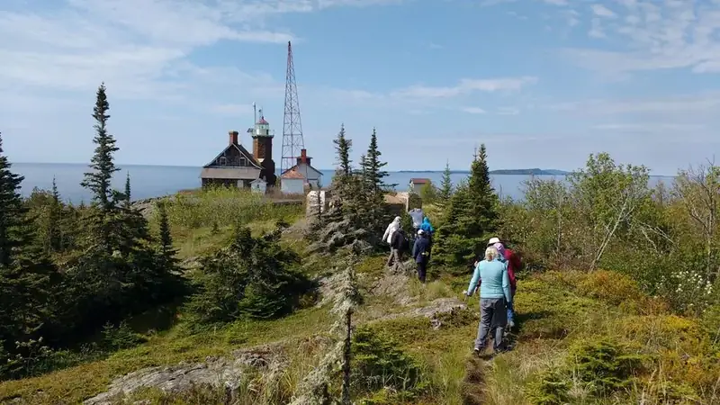 Visitors walk towards the end of an island with water surrounding it