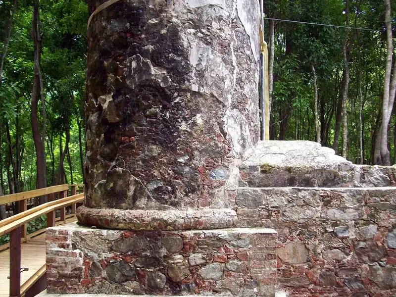 The wheelchair accessible boardwalk at Cinnamon Bay Loop Trail passes through lush green forest as it winds through the stone masonry ruins of Cinnamon Bay Plantation.